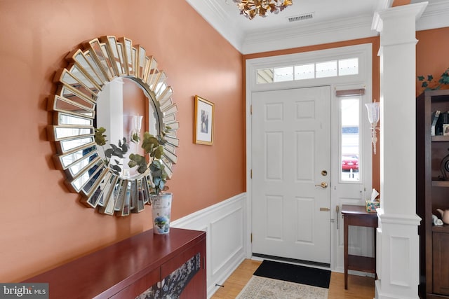 entrance foyer with decorative columns, light hardwood / wood-style flooring, and crown molding