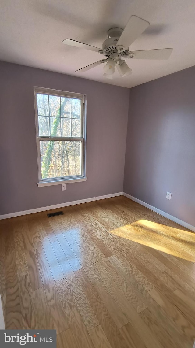 spare room featuring light hardwood / wood-style flooring and ceiling fan