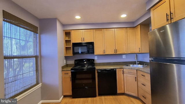 kitchen featuring black appliances, light hardwood / wood-style floors, and sink