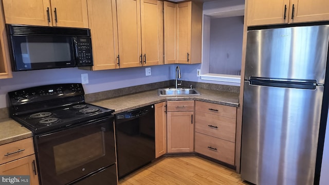 kitchen with black appliances, light hardwood / wood-style floors, sink, and light brown cabinets