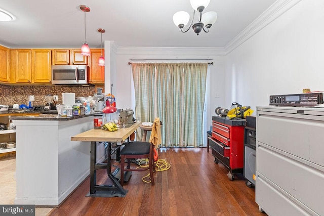 kitchen featuring a chandelier, decorative light fixtures, dark hardwood / wood-style floors, and ornamental molding