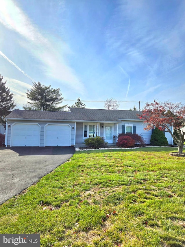 ranch-style home with a garage and a front lawn