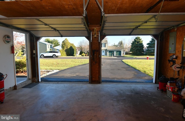 garage with electric panel and a yard