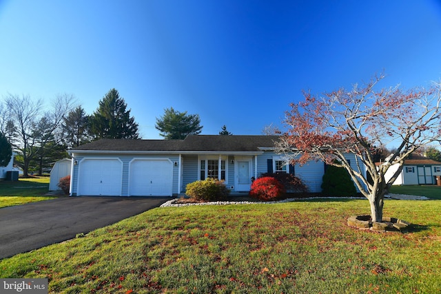 ranch-style home featuring a garage and a front lawn