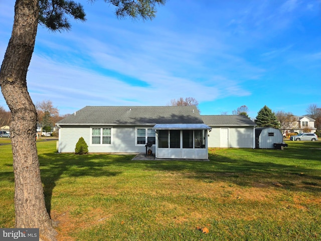 back of house with a sunroom, a shed, and a yard