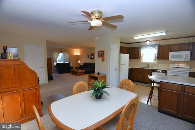 dining space with ceiling fan, sink, a wealth of natural light, and light tile patterned flooring