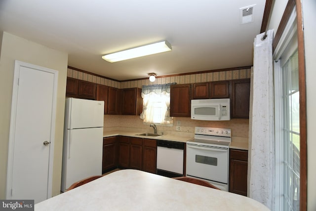 kitchen featuring white appliances, sink, and tasteful backsplash