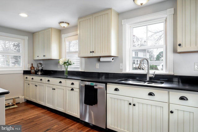 kitchen featuring plenty of natural light, sink, stainless steel dishwasher, and cream cabinets