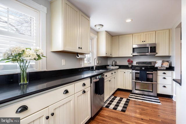 kitchen featuring appliances with stainless steel finishes, sink, and cream cabinets