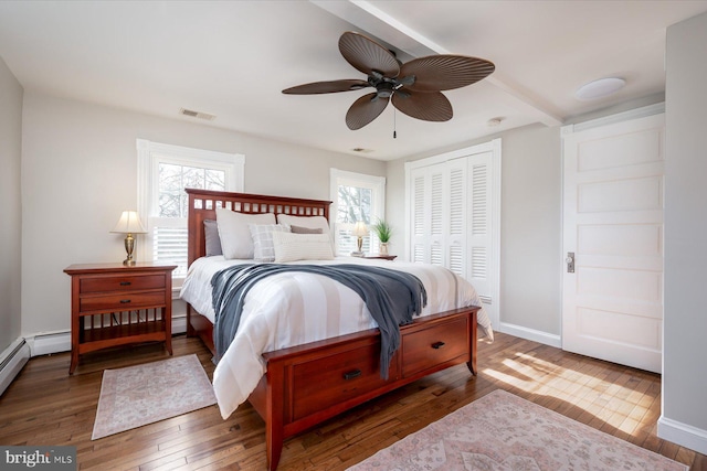 bedroom featuring multiple windows, dark hardwood / wood-style floors, and a closet