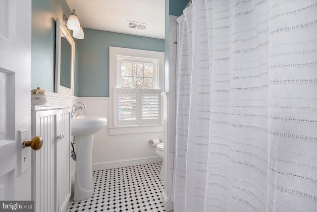 bathroom featuring a shower with shower curtain, toilet, and sink