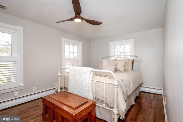 bedroom featuring a baseboard heating unit and dark hardwood / wood-style flooring