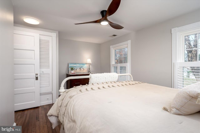 bedroom with dark hardwood / wood-style floors and ceiling fan