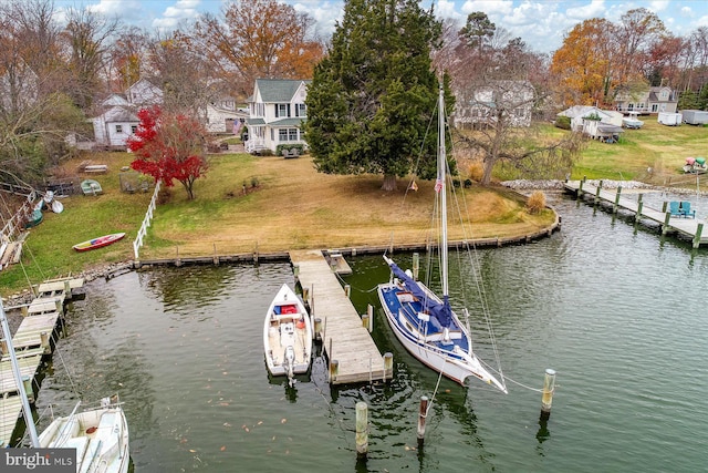 view of dock with a yard and a water view