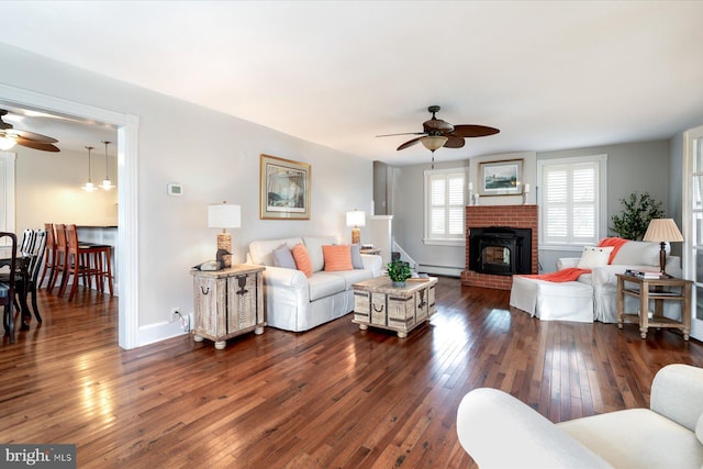 living room with ceiling fan, dark hardwood / wood-style floors, and a baseboard heating unit