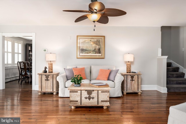 living room featuring dark hardwood / wood-style flooring, a baseboard heating unit, and ceiling fan