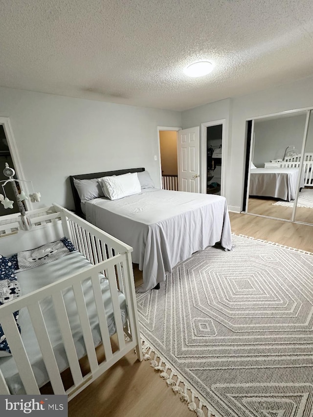 bedroom featuring wood-type flooring and a textured ceiling