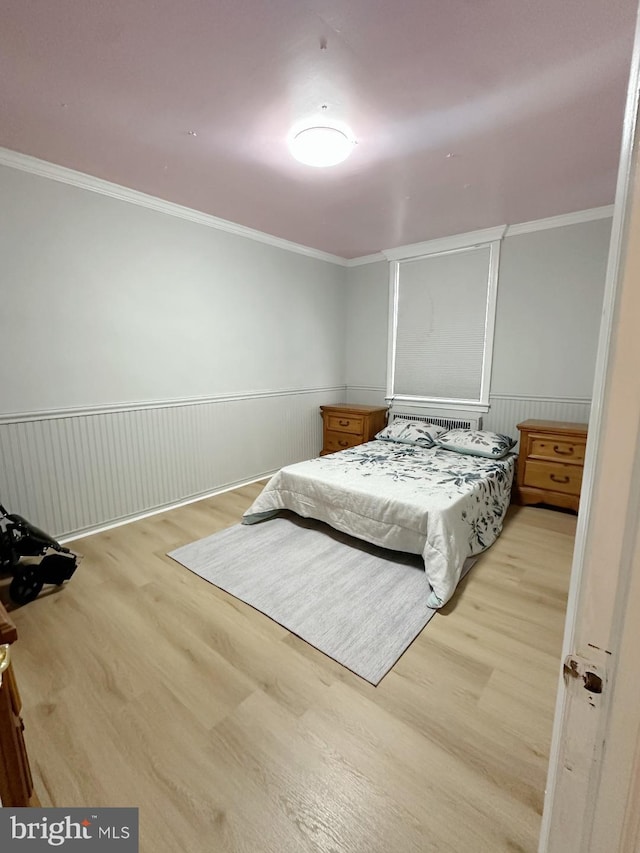 bedroom with light hardwood / wood-style floors and ornamental molding