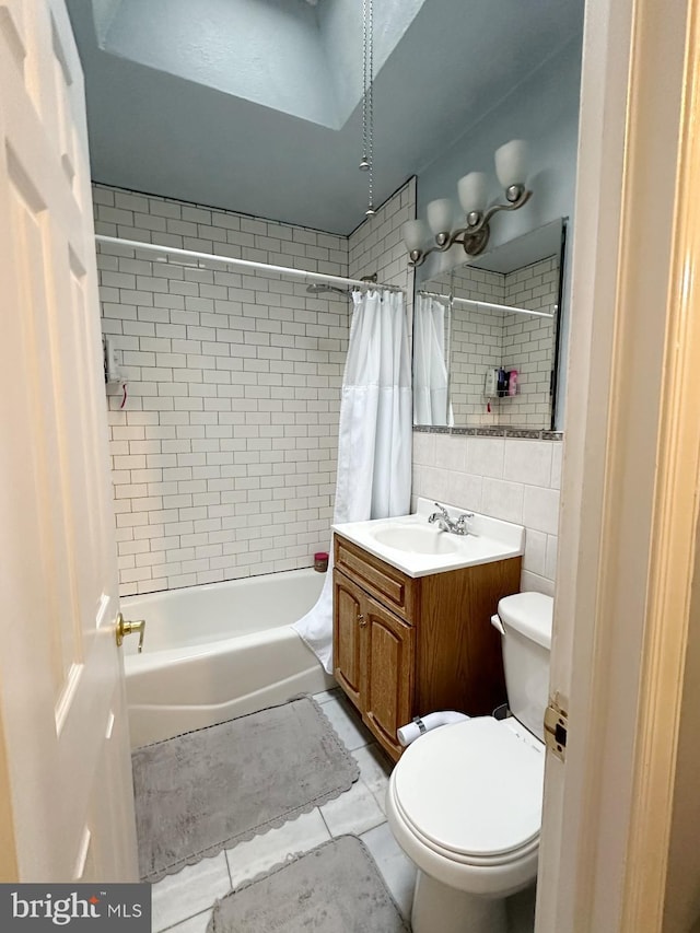 full bathroom featuring vanity, shower / bathtub combination with curtain, tile walls, tile patterned flooring, and toilet