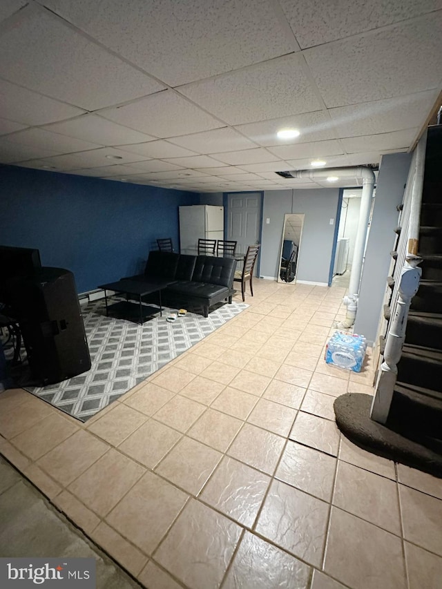 living room featuring tile patterned floors and a paneled ceiling