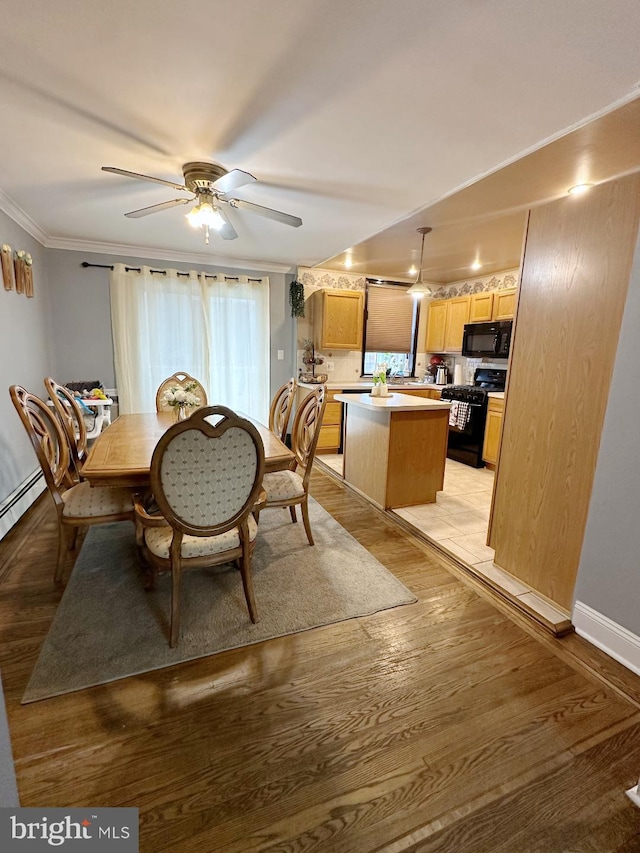 dining space featuring ceiling fan, crown molding, and light wood-type flooring