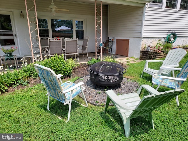 view of yard featuring a fire pit, ceiling fan, and a patio area