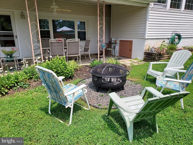 view of yard featuring a patio area, ceiling fan, and a fire pit