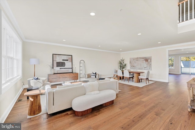 living room featuring light wood-type flooring and ornamental molding