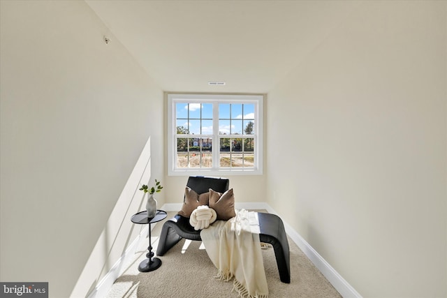 living area featuring light carpet