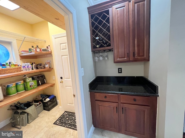 bar featuring baseboards and a dry bar