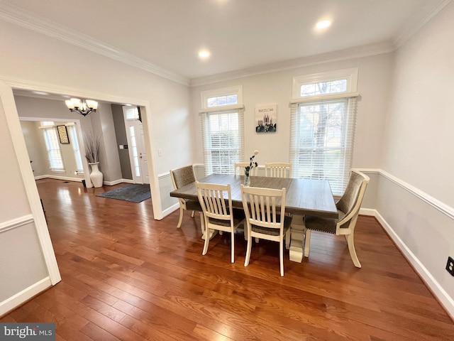 dining room with a chandelier, crown molding, baseboards, and wood-type flooring