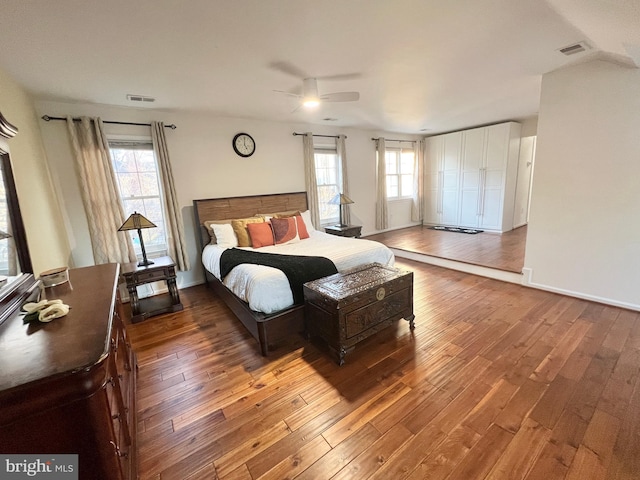 bedroom featuring baseboards, visible vents, wood-type flooring, and ceiling fan