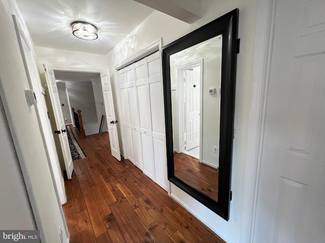 hall with an upstairs landing, baseboards, and dark wood-style flooring