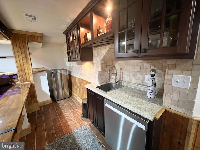 kitchen with visible vents, dark brown cabinets, wood finish floors, appliances with stainless steel finishes, and a sink