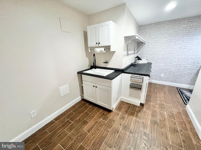 kitchen featuring white cabinetry, wood finish floors, and a sink