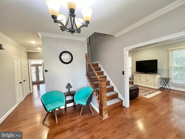 sitting room with crown molding, baseboards, stairs, a notable chandelier, and wood-type flooring