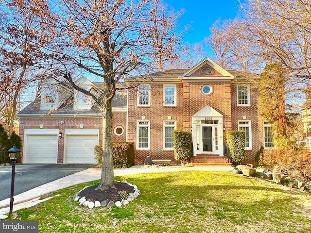 view of front of house with aphalt driveway, a front lawn, and brick siding