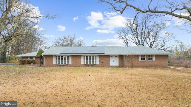 ranch-style house with solar panels and a front yard