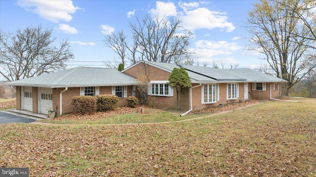 single story home featuring a front yard and a garage