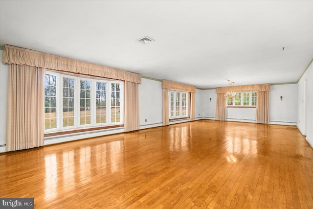 unfurnished living room featuring a chandelier, light hardwood / wood-style floors, and a baseboard radiator