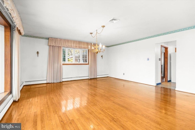 unfurnished room featuring light hardwood / wood-style flooring, a baseboard radiator, and a notable chandelier