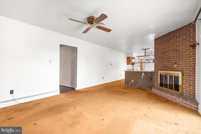 unfurnished living room with ceiling fan, a baseboard heating unit, carpet floors, and a brick fireplace