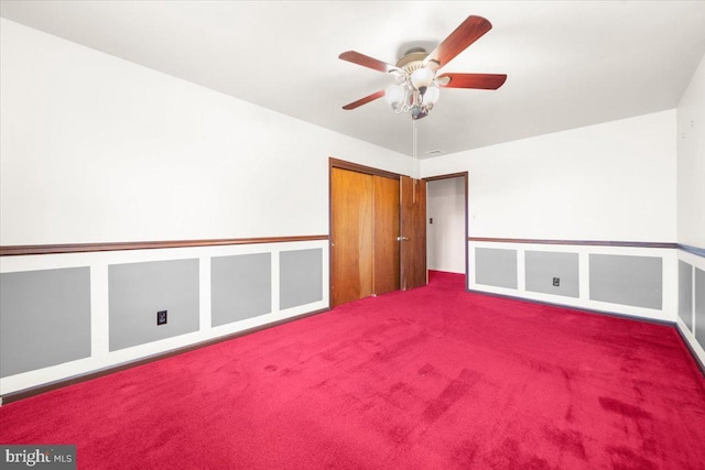 carpeted spare room featuring ceiling fan