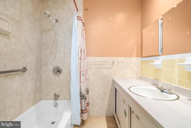 bathroom featuring tile patterned flooring, vanity, shower / bath combo with shower curtain, and tile walls