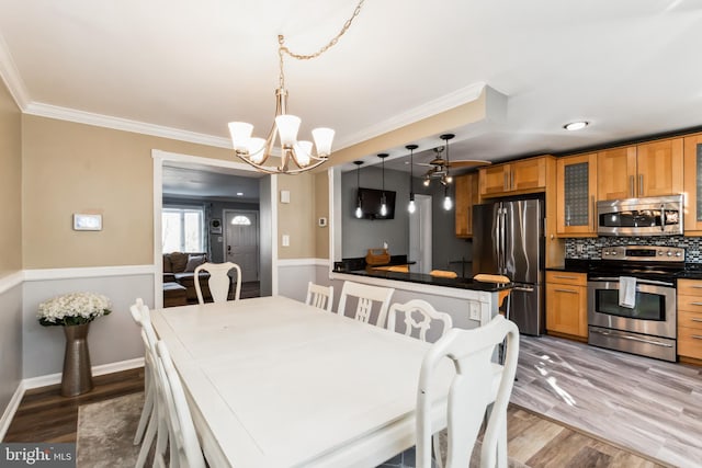 dining space featuring hardwood / wood-style floors, crown molding, and a notable chandelier