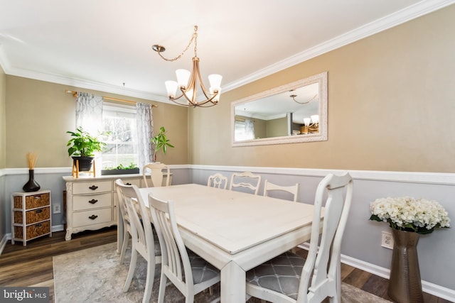 dining space featuring dark hardwood / wood-style flooring, crown molding, and an inviting chandelier