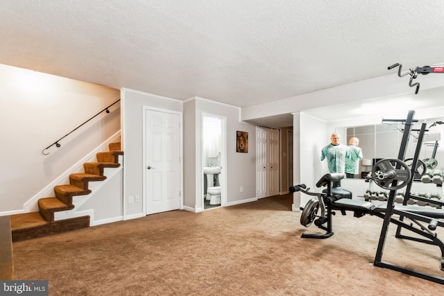 workout room with carpet flooring, ornamental molding, and a textured ceiling