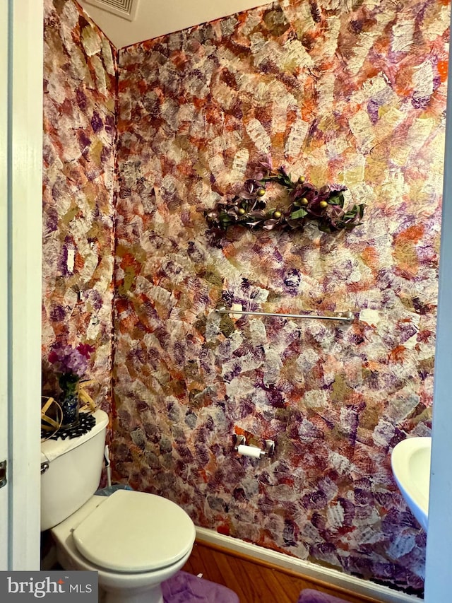 bathroom featuring hardwood / wood-style flooring and toilet