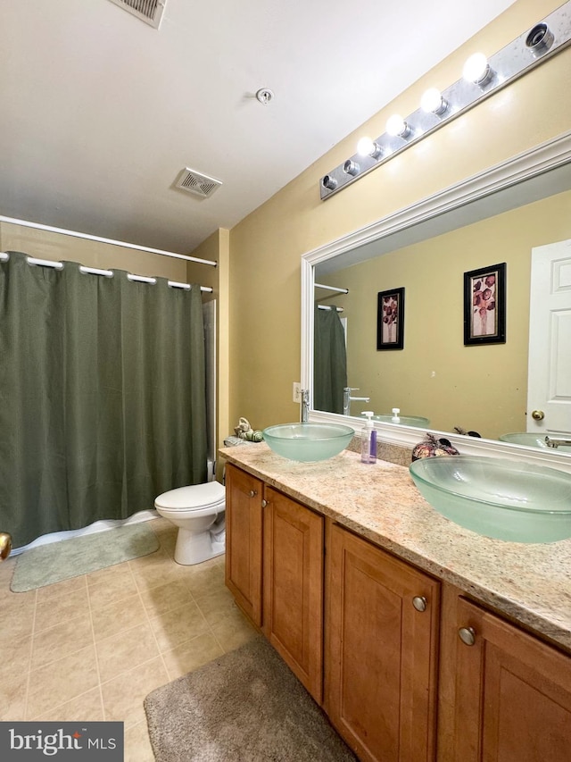 bathroom with tile patterned floors, vanity, and toilet