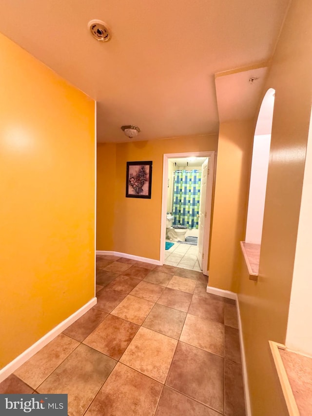 hall with tile patterned floors